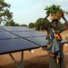 Jeune femme sénégalaise devant des panneaux solaires